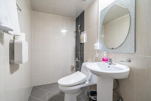 a bathroom with a sink and a toilet and a mirror at Hotel memory Jumunjin- Welcome drink provided in Gangneung