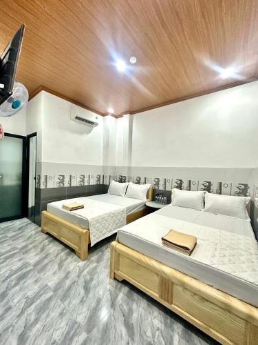 a bedroom with two beds and a wooden ceiling at THUẬN VƯƠNG Homestay in Vĩnh Hy