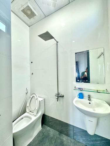 a white bathroom with a toilet and a sink at THUẬN VƯƠNG Homestay in Vĩnh Hy