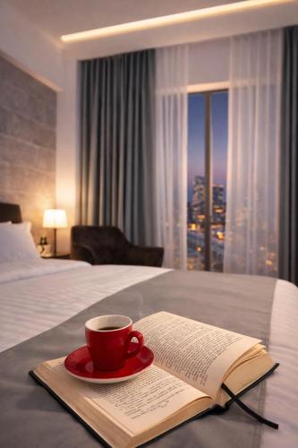 a cup of coffee and a book on a bed at No107 Predeal in Predeal