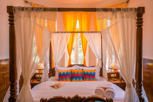 a bedroom with a canopy bed with a window at goSTOPS Ooty in Ooty