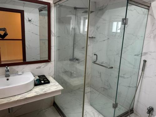 a bathroom with a shower and a sink at City Oasis Boutique Hotel in Lahore
