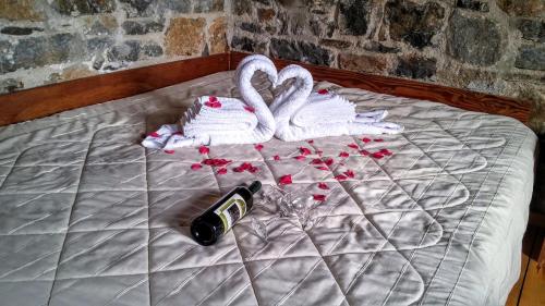 a bed with two swans and a bottle of champagne at Stratos Villas in Melidhónion