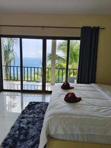 a bedroom with a bed with a view of the ocean at Koh tao two view in Ko Tao