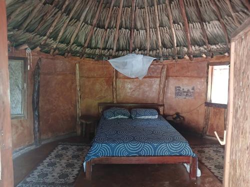 a bed in the inside of a thatched room at Private jungle accommodation with waterfall in Minca