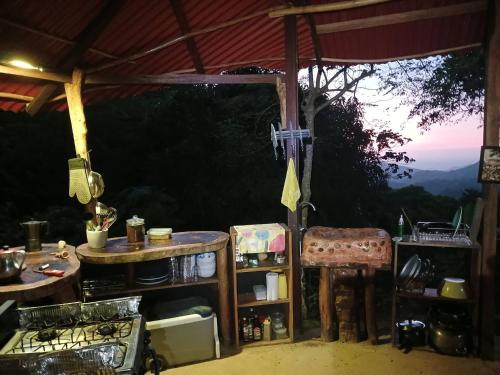 an outdoor kitchen with a table and chairs and a view at Private jungle accommodation with waterfall in Minca