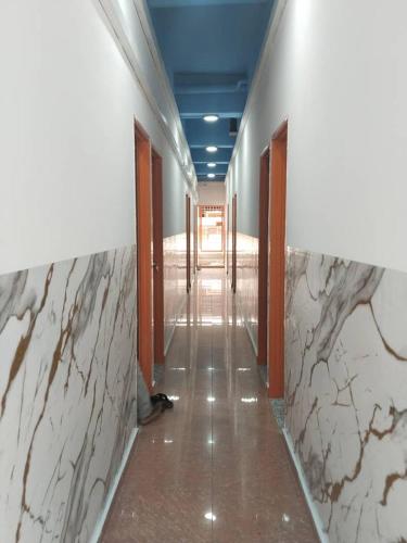 a hallway with white marble walls and a blue ceiling at H Sri Sayang Hotel Sdn Bhd in Skudai