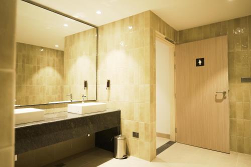 a bathroom with two sinks and a mirror at Round D Clock, IGI Airport in New Delhi