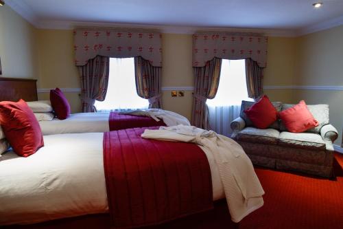 a hotel room with two beds and a couch at Best Western Lichfield City Centre The George Hotel in Lichfield