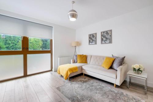 a living room with a couch and a window at Multiple 2-Bedroom Apartments near Harry Potter Studios - 2-Minute walk to Bushey Station - 20 Minutes to London Euston - Ideal for Families & Business - Free Parking in Watford