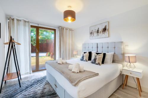 a bedroom with a large white bed and a window at Multiple 2-Bedroom Apartments near Harry Potter Studios - 2-Minute walk to Bushey Station - 20 Minutes to London Euston - Ideal for Families & Business - Free Parking in Watford