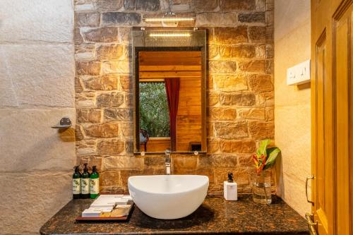 a bathroom with a sink and a mirror at Nature Trails Rock Valley, Goa in Ponda