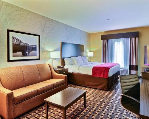 a hotel room with a bed and a couch at Comfort Suites Uniontown in Uniontown