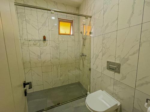 a bathroom with a shower and a toilet at Aqua Epic Residence in Mombasa