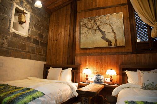 una camera con due letti e due tavoli con lampade di WuYuan QiYe YanXiang Guesthouse a Wuyuan