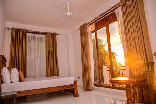 a living room with a large window with a bench and a window at Windsor in Kandy