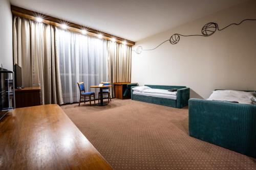 a living room with a couch and a bed and a table at Hotel Opava - free parking in Opava