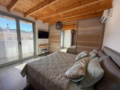 a bedroom with a bed and a large window at Spitaki in Kremasti