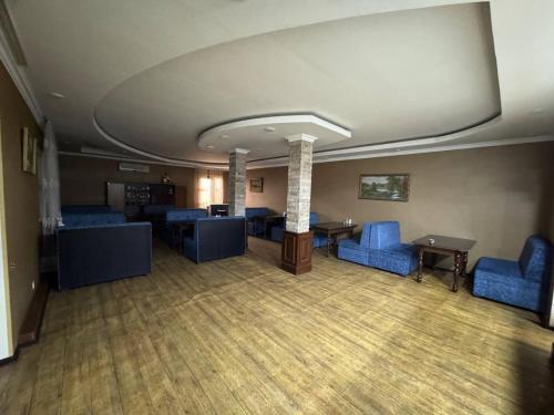 a room with blue chairs and a table in a building at Hafiz Plaza Hotel in Tashkent
