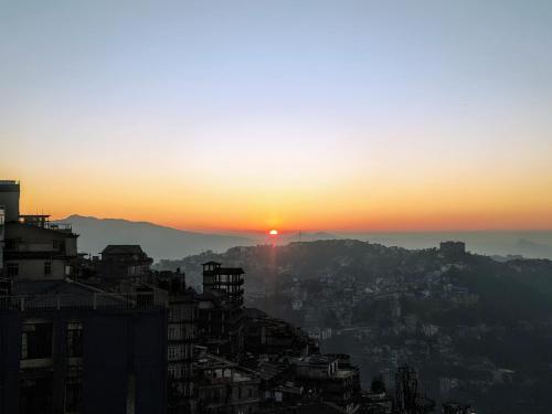a view of the sun setting over a city at Mizotel in Āīzawl