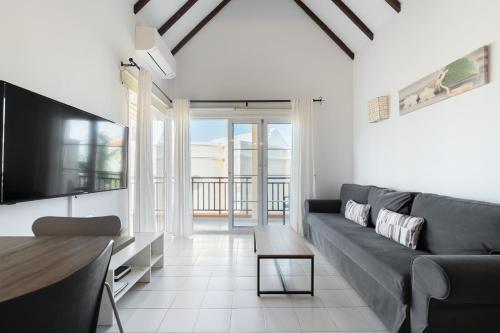 a living room with a couch and a tv at Benny Fañabé - 2 Bed and Loft Apartment, AC, Pool & Parking in Adeje