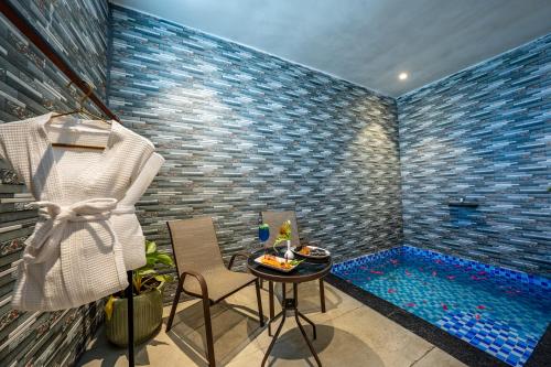 a room with a small table and a swimming pool at Leafy Lush Resort and Spa in Rāmnagar