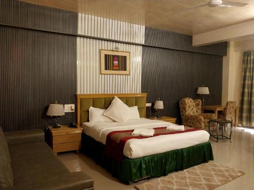 a hotel room with a bed and a chair at Mango Valley Resort Ganpatipule in Ratnagiri