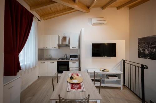 a kitchen with a table and a small kitchen with a table and chairs at Appartamento Bastione in Riva del Garda