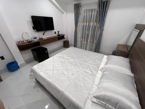 a bedroom with a bed and a flat screen tv at H99 Homestay in Ðông Bình (2)