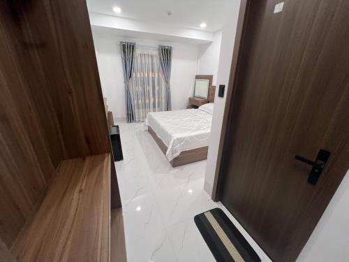 a bedroom with a bed and a wooden door at H99 Homestay in Ðông Bình (2)