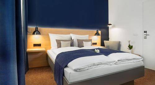 a bedroom with a large bed with a blue wall at Bischoffs Hotel in Bad Urach