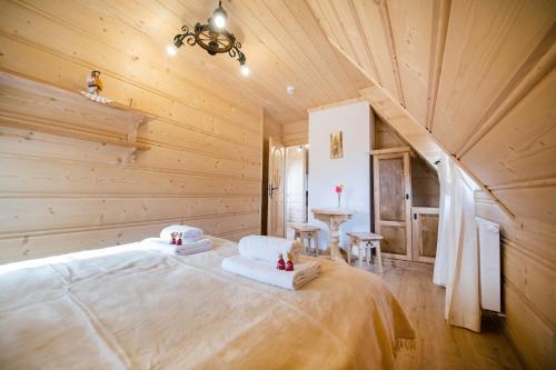 a bedroom with a large bed in a wooden room at Smrekowy Dworek in Kościelisko