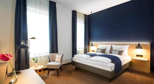 Schlafzimmer mit einem Kingsize-Bett und einem Stuhl in der Unterkunft Bischoffs Hotel in Bad Urach