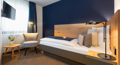 a hotel room with a bed and a chair at Bischoffs Hotel in Bad Urach