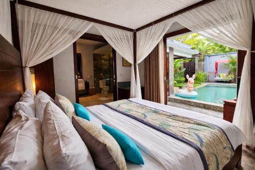 a bedroom with a bed and a swimming pool at Seminyak Icon - by Karaniya Experience - CHSE certified in Seminyak