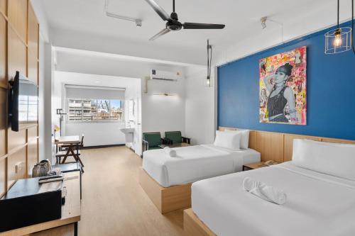 a bedroom with two beds and a blue wall at River View Residence in Bangkok