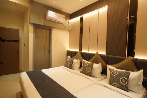 a bedroom with a large bed with pillows at The Grand Sarayu in Mysore