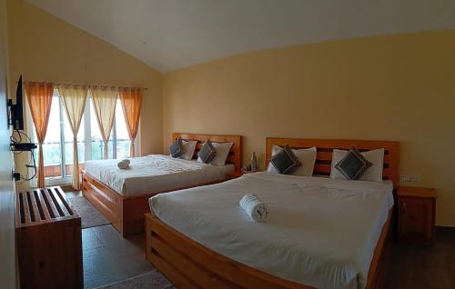 a bedroom with two beds and a window at Longwood Resorts in Kotagiri