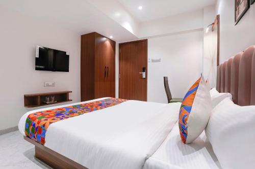 a bedroom with a bed and a tv on a wall at FabHotel Suruchi Homes in Vasai
