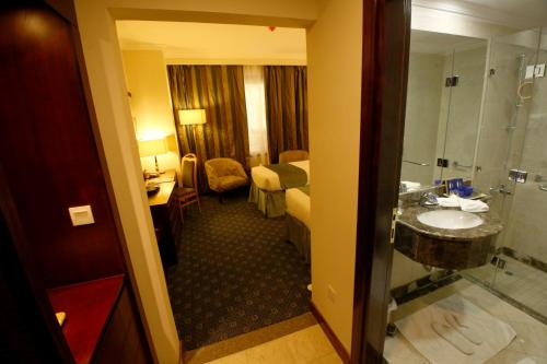 a hotel room with a bathroom and a sink at Al Aqeeq Al Rawda Hotel by Abu Al Joud in Al Madinah