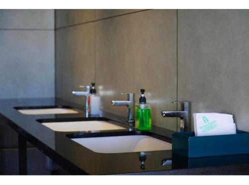 a row of sinks in a public bathroom at Clouds end Resorts Munnar in Jāmb