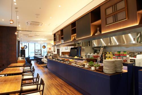a kitchen filled with lots of tables and chairs at Sotetsu Fresa Inn Ginza-Nanachome in Tokyo