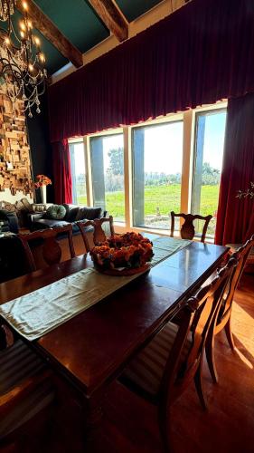 a dining room table with a bowl of fruit on it at Finca Vidandrei CASA MAZAHUA in Valle de Guadalupe