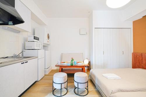 a small kitchen with a table and stools in a room at Momotarou Stay in Yokohama