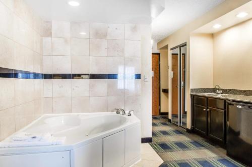a bathroom with a white tub and a sink at Comfort Inn & Suites Meriden East in Meriden