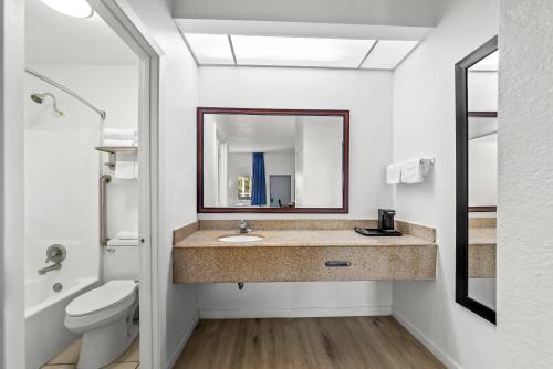 a bathroom with a sink and a toilet and a mirror at Quality Inn Weeki Wachee - Spring Hill in Weeki Wachee