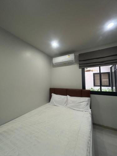 a small bedroom with a bed and a window at Hillside - Seashore Naiyang Beach in Phuket