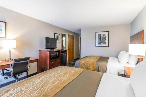 a hotel room with two beds and a flat screen tv at Comfort Inn SW Omaha I-80 in Omaha