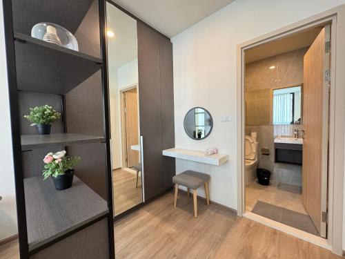 a bathroom with a mirror and a table and a chair at NUE District Rama 9 Condo in Bangkok
