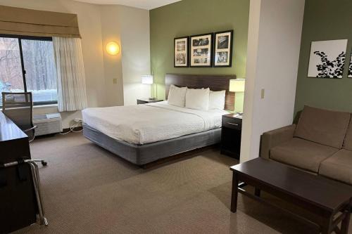 a hotel room with a bed and a couch at Sleep Inn & Suites Queensbury - Lake George in Queensbury